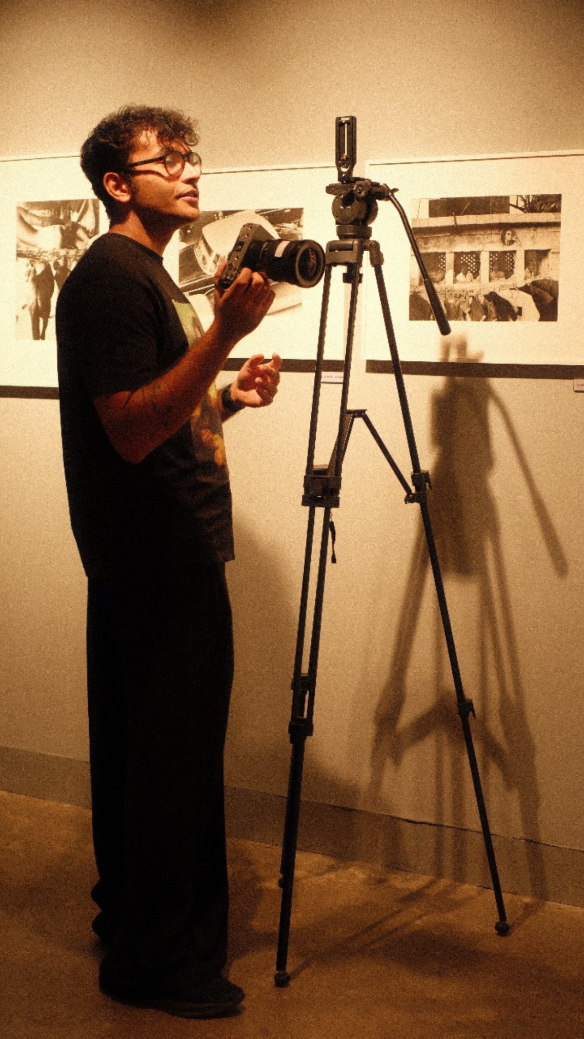 Shaurya Singh holding a camera beside a tripod